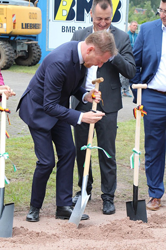 Foto: Ministerpräsidenten Michael Kretschmer signiert vor dem ersten Spatenstich eine Schaufel als Erinnerungsstück.